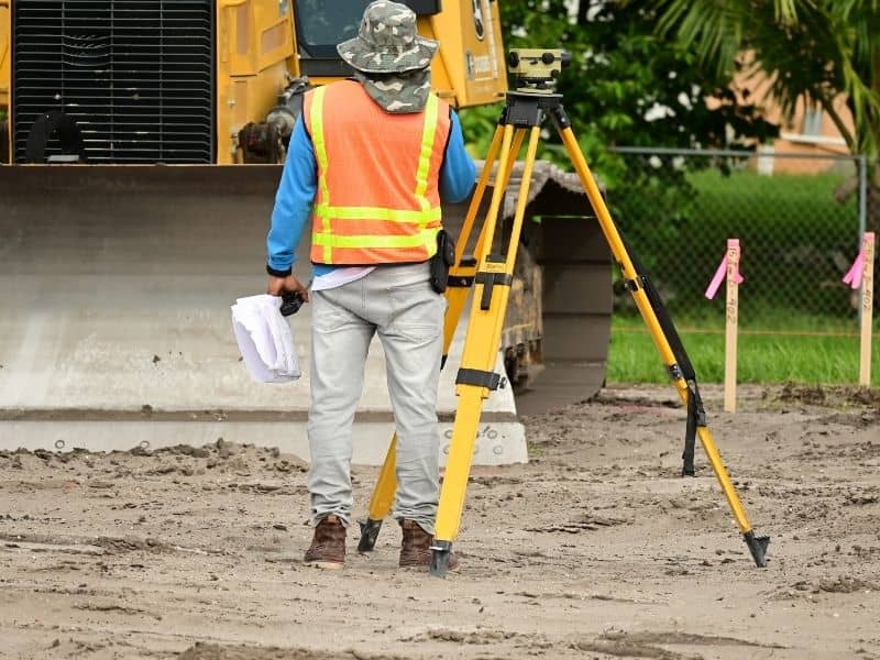Boundary survey with a land surveyor marking and measuring a development site
