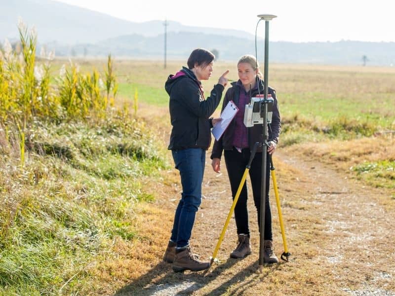 Surveyors using GPS equipment to collect topographic survey data and map land elevation features