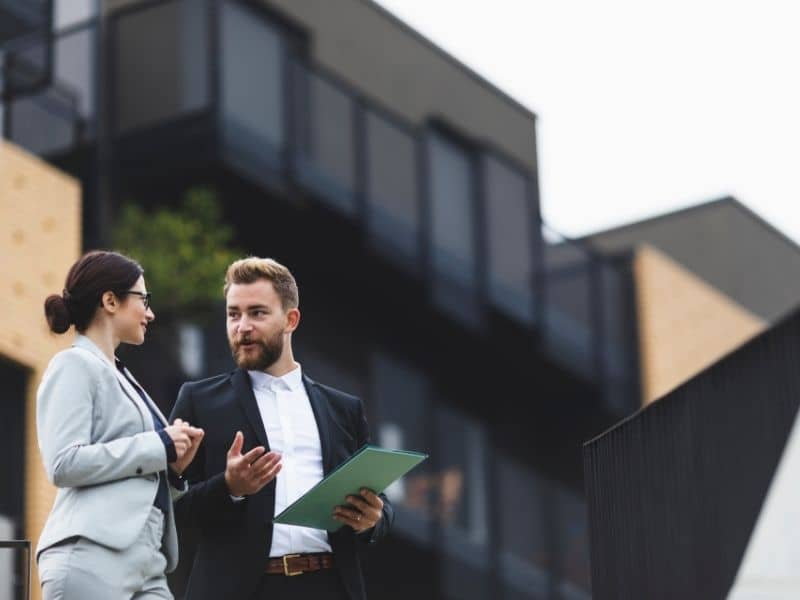 Business professionals discussing a commercial property investment before completing due diligence and reviewing an ALTA Survey.