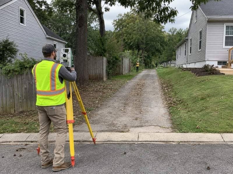 Boundary survey crew measuring a narrow flag lot access strip in Nashville, Tennessee.